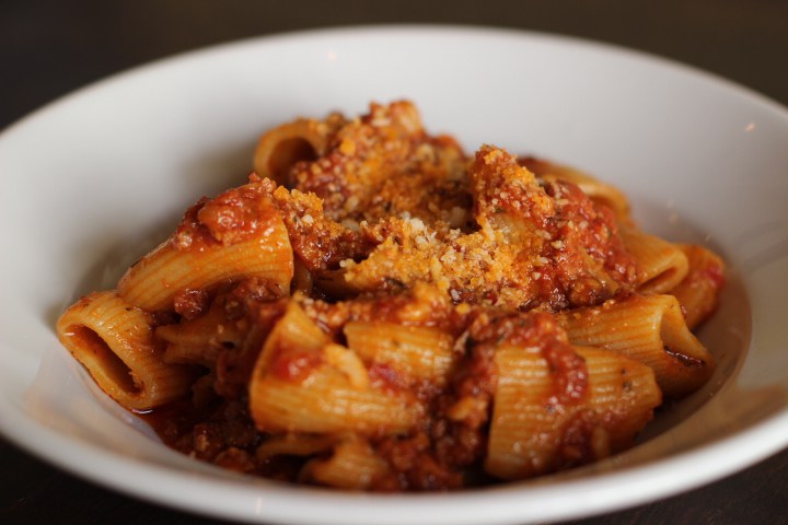 A small bowl of rigatoni covered in cheese and tomato sauce