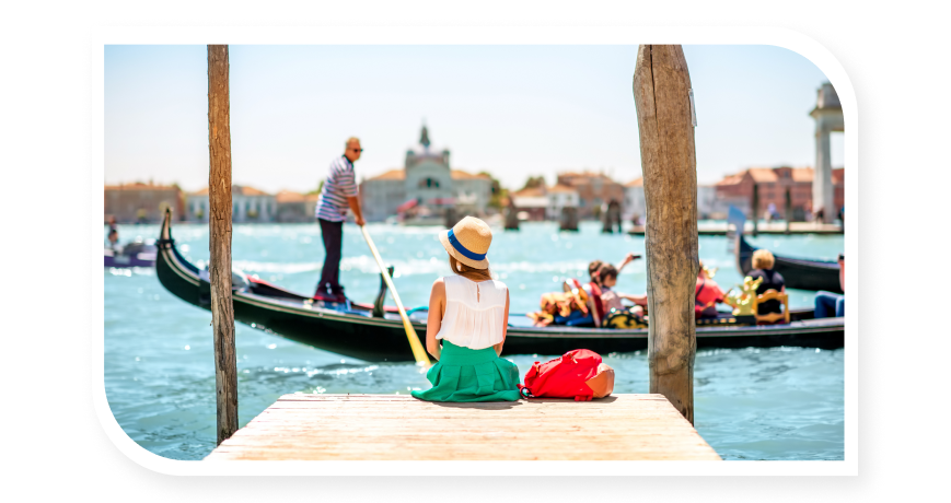 Girl sitting watching a gondola in Venice