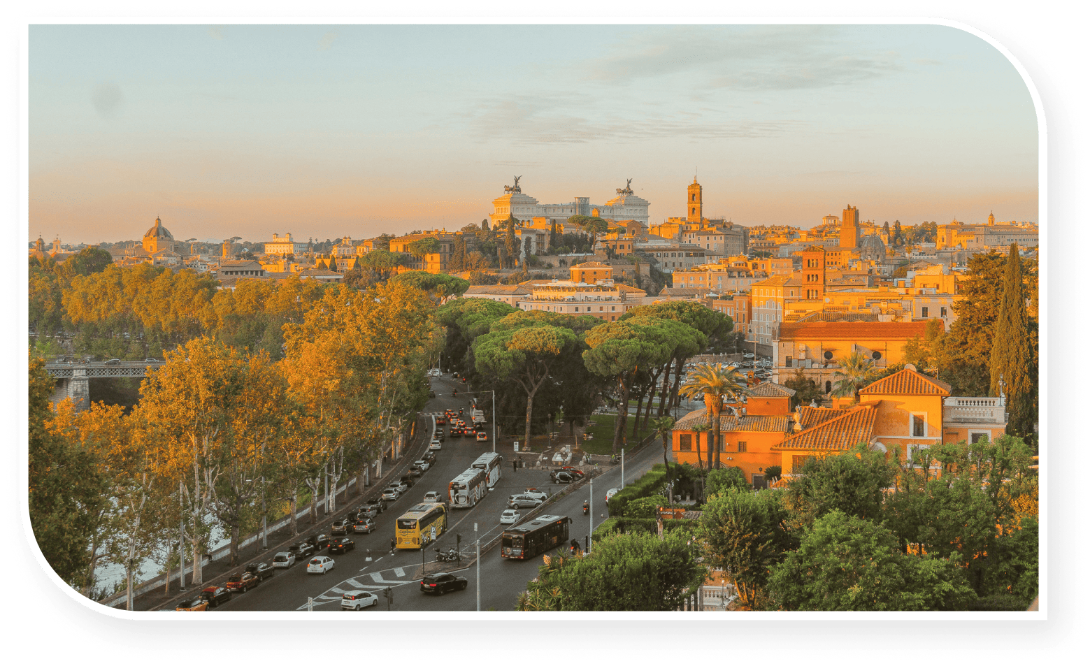 Panoramic view of Rome at sunset, with iconic landmarks, tree-lined streets, and golden-hued buildings under a soft orange sky."